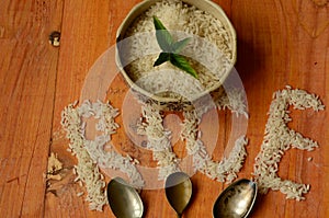 Rice in vintage bowl with three vintage teaspoons on wooden background, reis, arroz, riso, riz, Ñ€Ð¸Ñ.